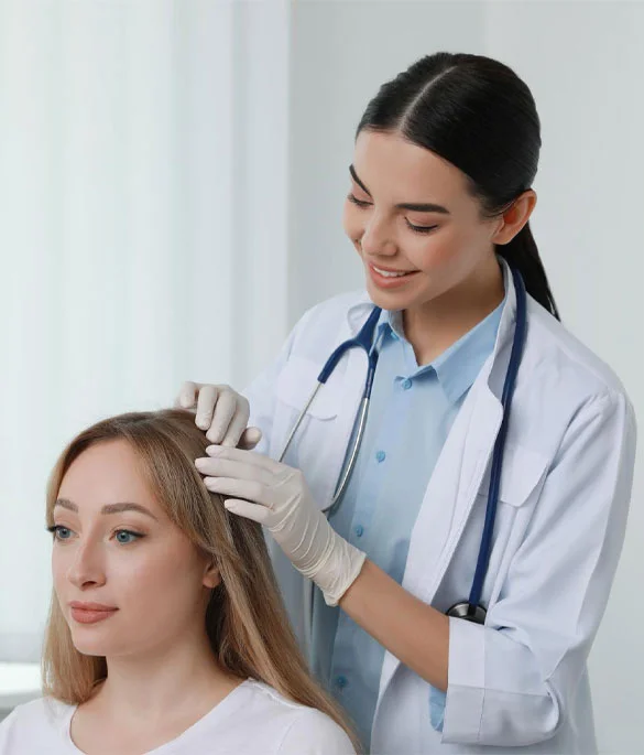 A dermatologist examining a female patient’s scalp for advanced skin and hair treatment at Dr. Thaj Clinic.